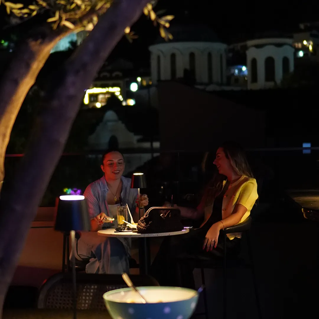 Guests at a lamp-lit table at night