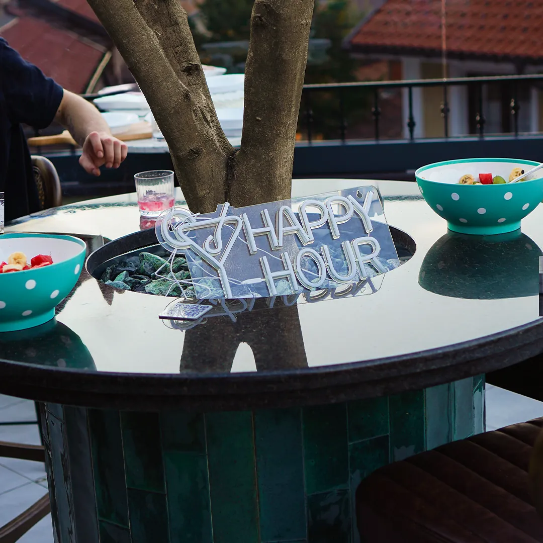 Happy Hour neon sign on the tree table