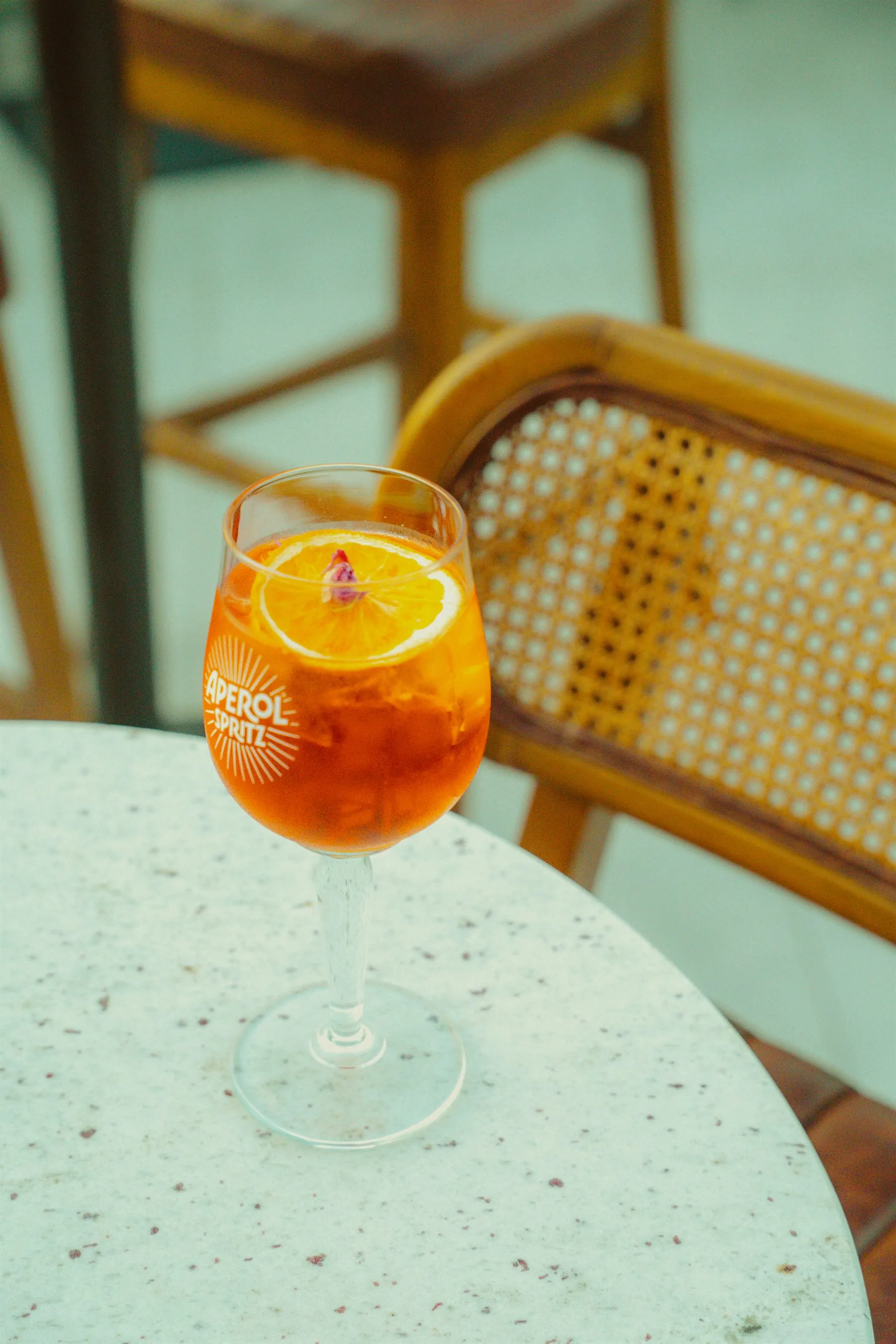 An Aperol spritz on a terrazzo table in the afternoon sun